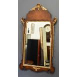 A reproduction mahogany and gold painted wall mirror, with shell and foliate scroll carved