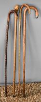 A group of four walking canes of various form.
