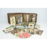 An album of Edwardian and later postcards together with an album of British and worldwide stamps.