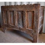 A 19th century carved chest, the planked top above a four panel front, carved with decoration and