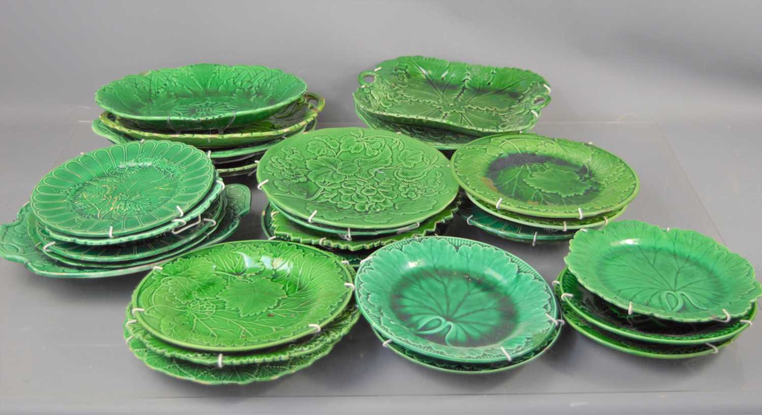 A large group of Majolica green glazed leaf design plates, dishes and other items.