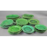 A large group of Majolica green glazed leaf design plates, dishes and other items.