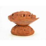 A Chinese nut boat sculpture on stand, intricately carved with passengers looking out, the underside