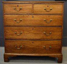 A Georgian elm chest of drawers, the two short over three long drawers raised above bracket feet,