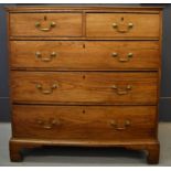 A Georgian elm chest of drawers, the two short over three long drawers raised above bracket feet,