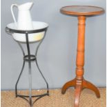 A mahogany torchere together with an enamel wash bowl and jug on a wrought iron stand.