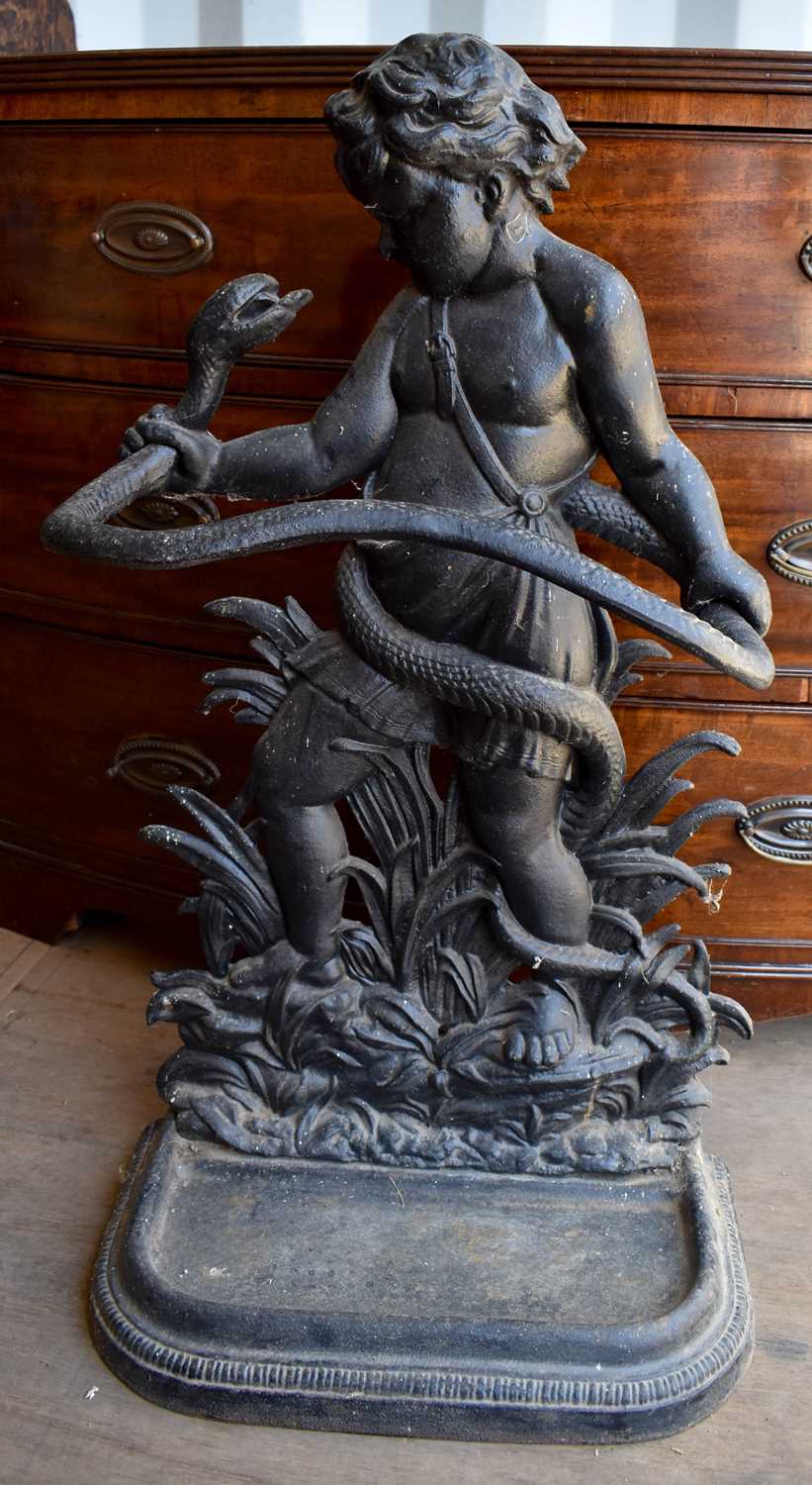 A cast iron umbrella stand in the form of a cherub and snake.