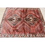 A Persian wool rug with red / brown ground, hand woven in soft pile, the centre with decorative