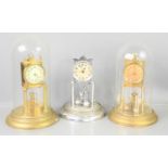 Three 20th century torsion pendulum clocks, two with glass domes.