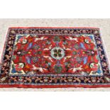 A fine Middle Eastern wool rug, hand woven in deep pile, the red ground centre depicting birds,