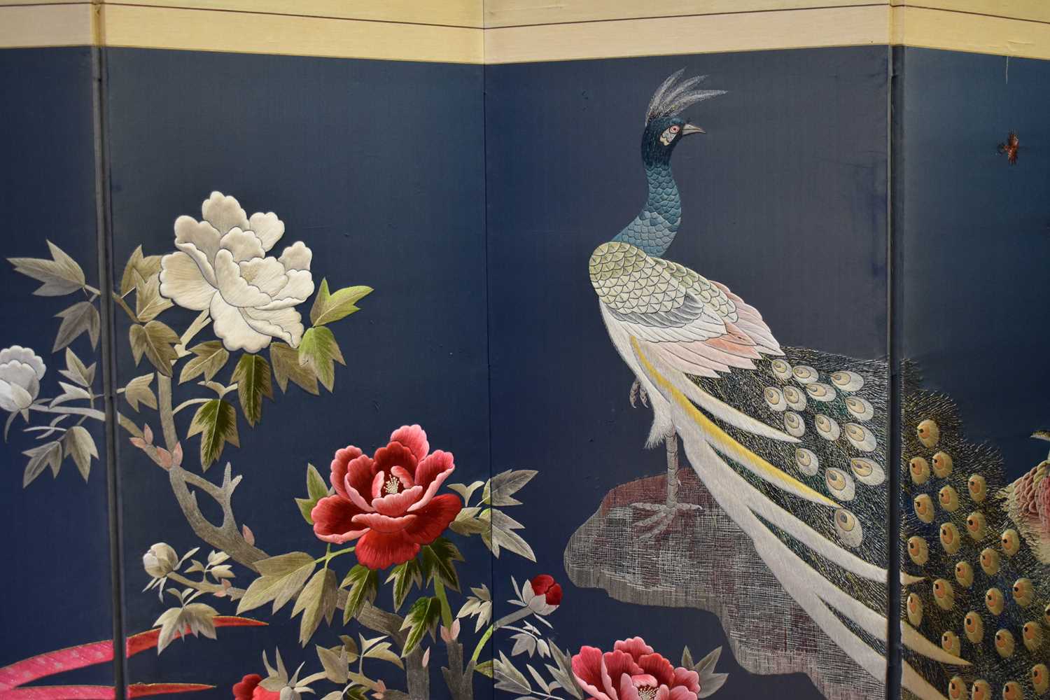 A 20th century embroidered Chinese panel depicting peacock amidst flowers, on a dark blue ground, - Bild 2 aus 2