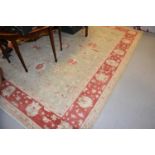 Large pale green and cream rug with deep red details and a wide border, 275cms by 348cms