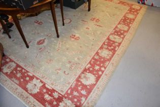 Large pale green and cream rug with deep red details and a wide border, 275cms by 348cms