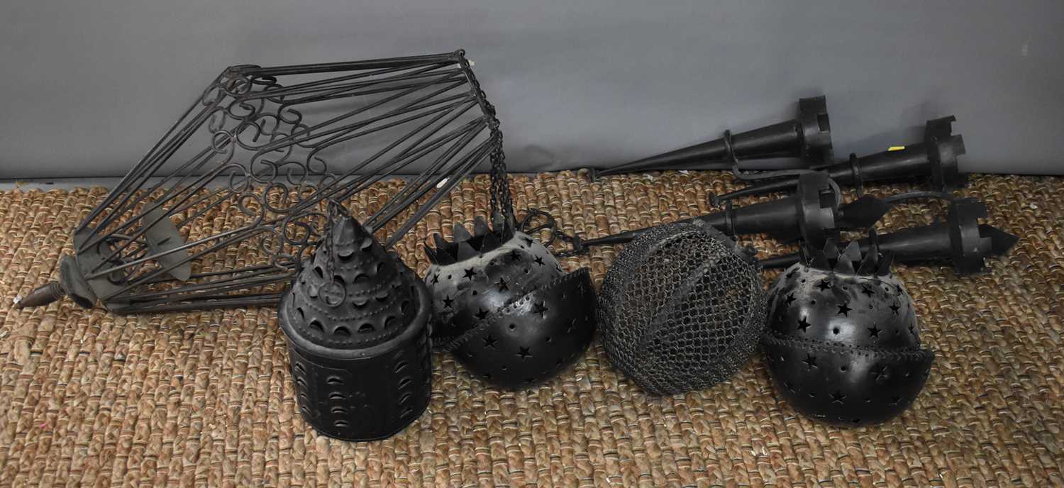 A group of medieval style metalware, to include two wall sconces, an ironwork basket shade, and four