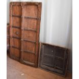 A wooden carved pair of window shutters, together with a wooden window and frame.