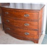 A 19th century mahogany three drawer bow front chest, which splits in the middle, raised on