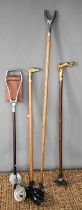A vintage shooting stick, crook, and two brass handled walking canes; one in the form of a dog head,
