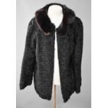A black Astrachan coat with faux fur collar.