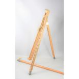 A pine floor standing artist's easel together with two antique walking canes.