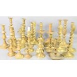 A large group of 19th century brass candlesticks of various styles.