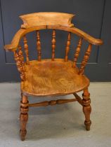 A 19th century smokers bow armchair, with turned spindle back, shaped seat and turned legs and H