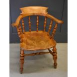 A 19th century smokers bow armchair, with turned spindle back, shaped seat and turned legs and H
