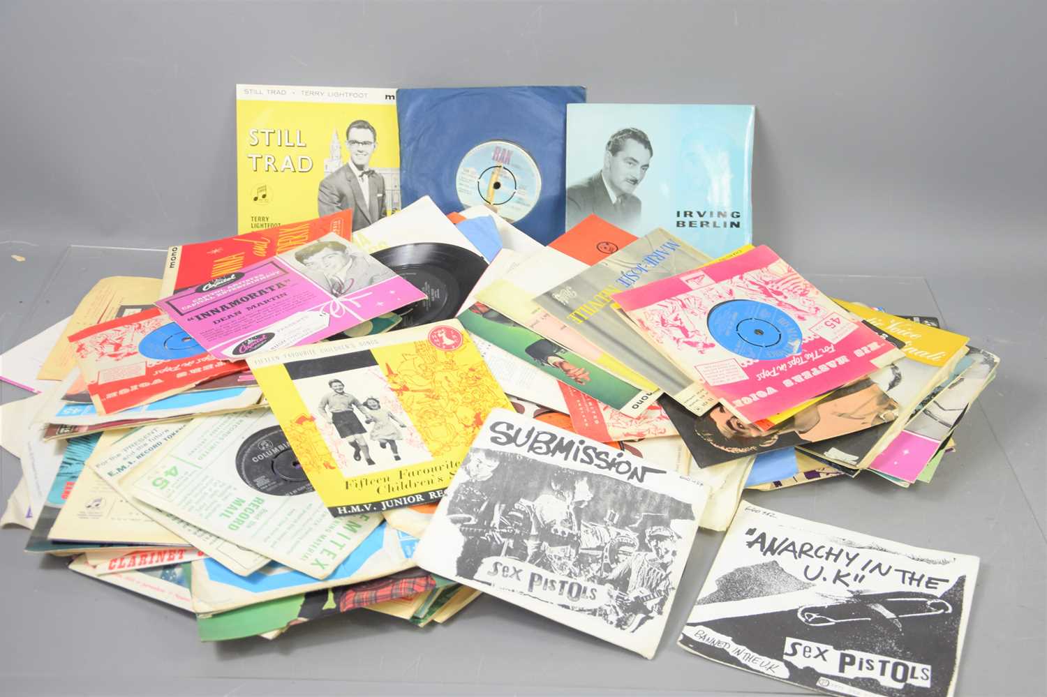 A group of 7" single records to include Ray Burns, Elvis Presley, George Browney, Johnathan King,