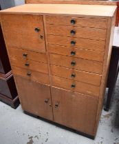 A mid century beech haberdashery cabinet, comprising various drawer and cupboard doors. 106cms