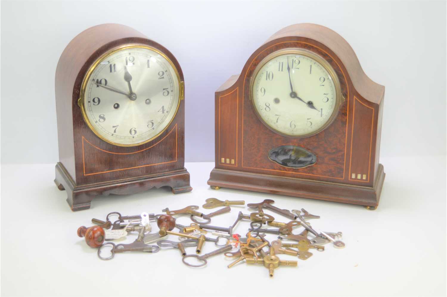 Two mahogany cased mantel clocks with a quantity of clock keys.