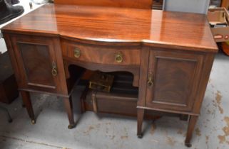 An early 20th century sideboard, with bow front drawer flanked by cupboards, raised on square