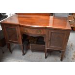 An early 20th century sideboard, with bow front drawer flanked by cupboards, raised on square