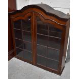 An Edwardian mahogany wall display cabinet, with two glazed doors enclosing shelved interior.