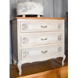 A painted French style chest of drawers, the three drawers with carved decoration, and short