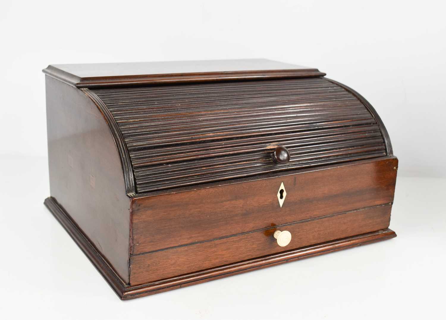 A 19th century mahogany roll top stationary box, the tambour slide opens to reveal a fitted