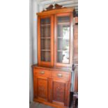 An Edwardian mahogany book case, the two glazed upper doors enclosing shelves, above two drawers and