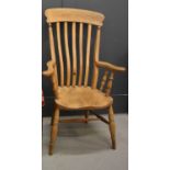 An antique pine kitchen armchair, 115cm high.