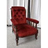 A Victorian mahogany armchair, upholstered in red velour, with button back and arms raised on