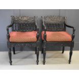 A pair of exeptional Anglo Indian ebony carved armchairs, circa 1840, Ceylonese, the shaped and