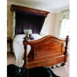 A Victorian mahogany half tester bed, with drapes, serpentine end board flanked by turned