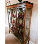 An Edwardian mahogany display cabinet, with glazed panels and doors decorated with astrigals,