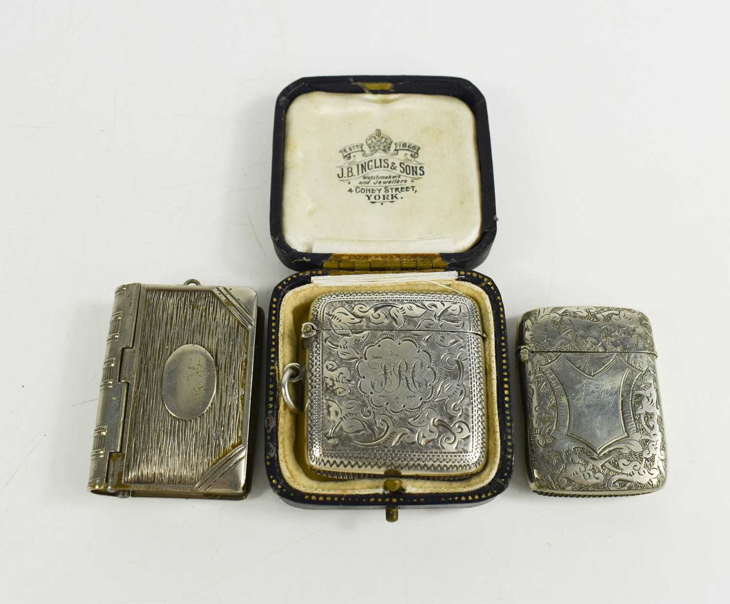 A 19th century silver vesta case engraved with chased decoration and initials, together with the