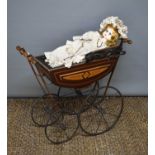 A Victorian pram together with a modern doll in a Victorian dress, pram measures 61cms tall by 69cms