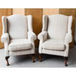 A pair of modern wingback armchairs, upholstered in pale check pattern, 109cms tall by 78cms wide by