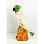 An early 20th century Staffordshire parrot, with green face and tail, the white body with gilded