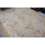 A large modern rug in the French style, with cream ground and orange borders, 275cms by 368cms