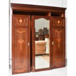 An Edwardian mahogany wardrobe, inlaid with decoration to the panelled doors which flank a central