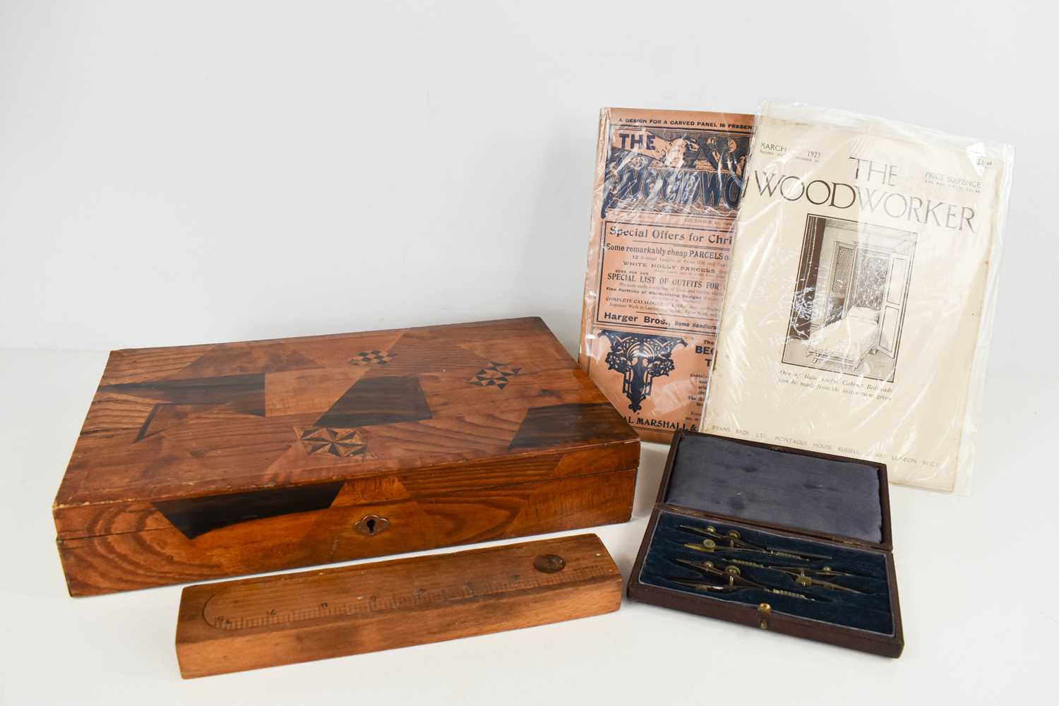 An antique parquetry box together with a treen pencil holder with sliding rule lid, a boxed set of