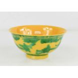 A Chinese porcelain bowl, in yellow glaze with incised and green painted decoration and figural