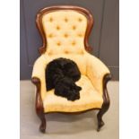 A Victorian mahogany and cream/yellow upholstered armchair with button back, 101cm high.