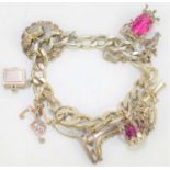 A sterling silver charm bracelet with fourteen charms to include a bible, ice skate, three pence,